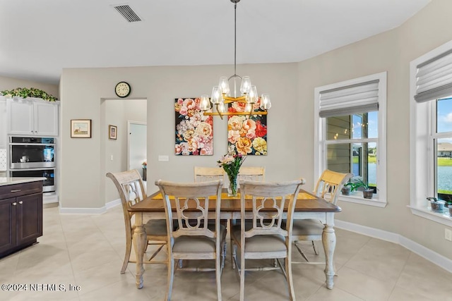 dining space with light tile floors and an inviting chandelier