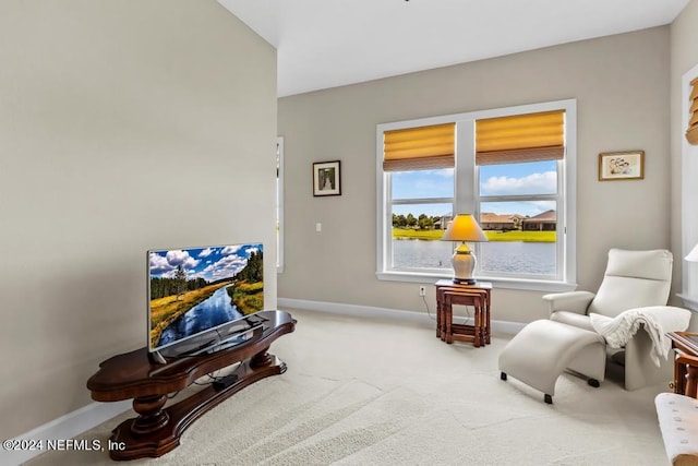 living area featuring carpet floors and a water view