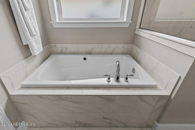 bathroom with a relaxing tiled bath