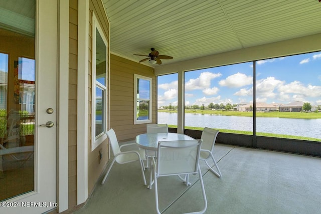 sunroom / solarium featuring a water view and ceiling fan