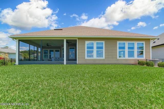 rear view of house featuring central AC, ceiling fan, and a lawn