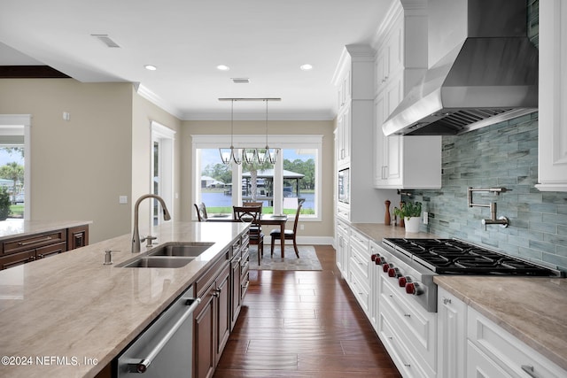 kitchen featuring stainless steel appliances, sink, wall chimney range hood, and white cabinets