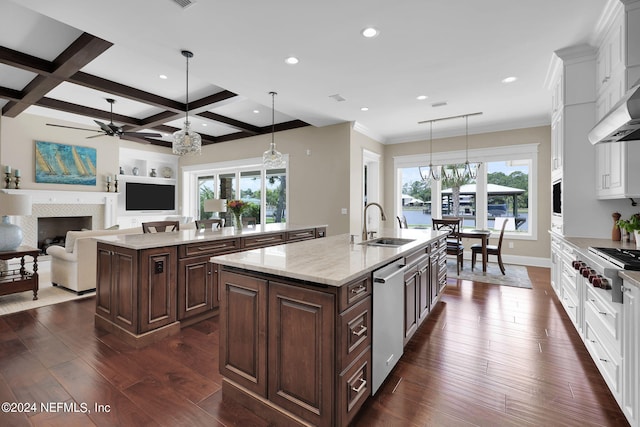 kitchen with dark brown cabinetry, white cabinetry, decorative light fixtures, a center island with sink, and appliances with stainless steel finishes