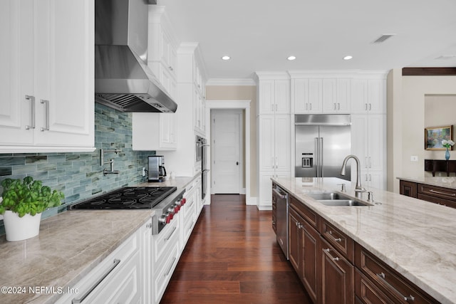 kitchen featuring dark brown cabinetry, wall chimney exhaust hood, stainless steel appliances, and sink