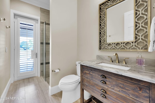 bathroom featuring vanity, a shower with shower door, and toilet