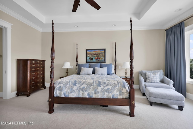 bedroom with crown molding, ceiling fan, a tray ceiling, and light carpet