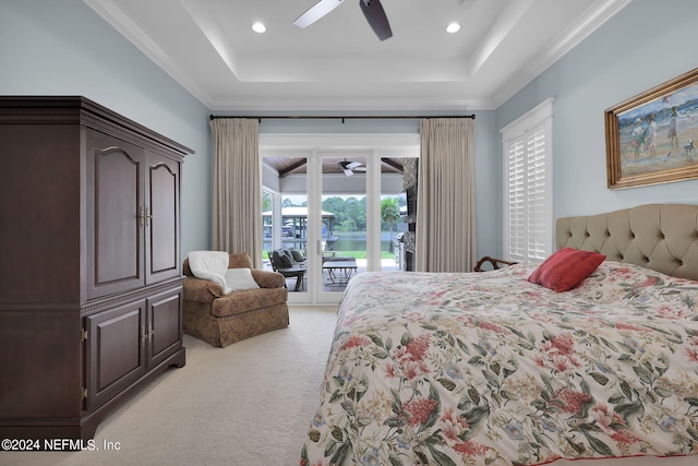 carpeted bedroom with a tray ceiling, access to outside, ornamental molding, and ceiling fan