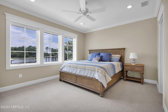 carpeted bedroom with ornamental molding and ceiling fan