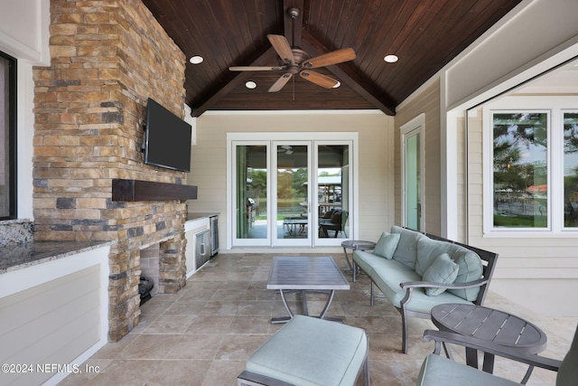 view of patio featuring an outdoor stone fireplace and ceiling fan