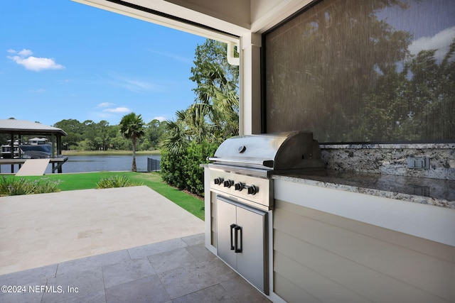 view of patio / terrace with a grill, a gazebo, an outdoor kitchen, and a water view