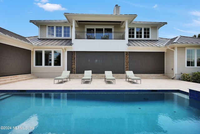 back of property with a balcony and a patio