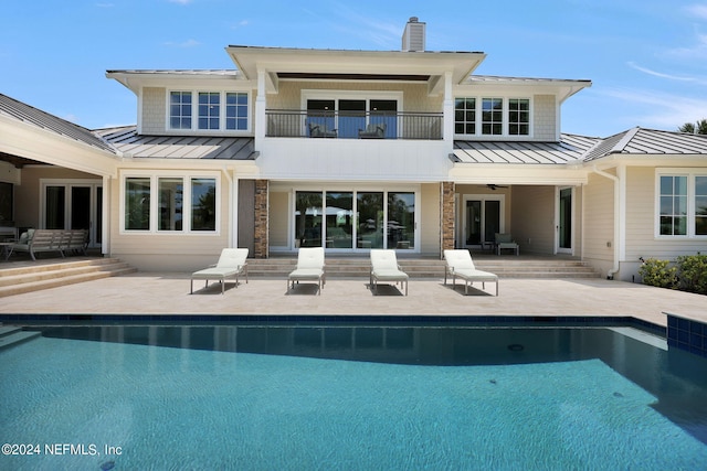 rear view of house with a patio area and a balcony