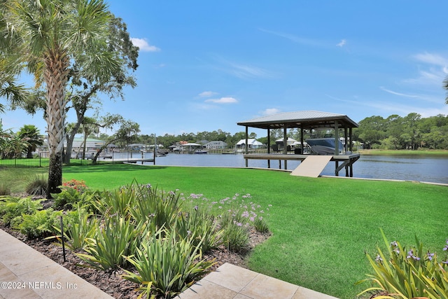 dock area with a lawn and a water view