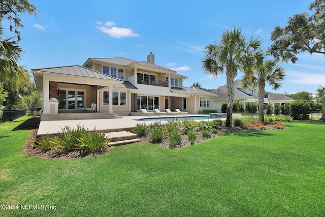 back of house featuring a lawn and a patio