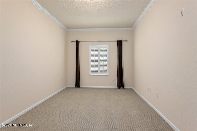 empty room with ornamental molding, a textured ceiling, and light colored carpet