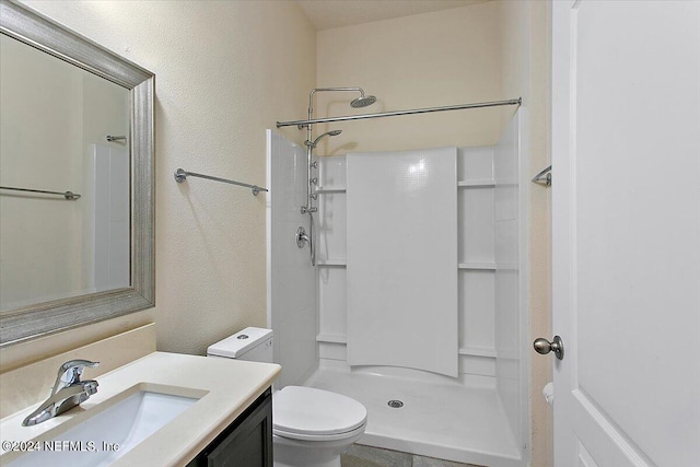 bathroom with walk in shower, toilet, and vanity