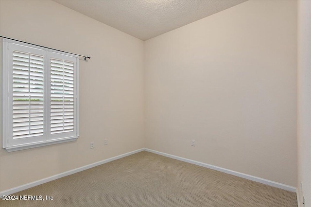 carpeted empty room with a textured ceiling