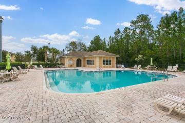 pool with a patio area and fence