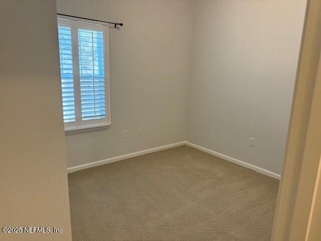 spare room with baseboards, a healthy amount of sunlight, and carpet flooring