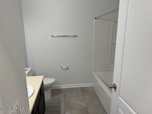 full bathroom with toilet, vanity, shower / tub combination, tile patterned flooring, and baseboards