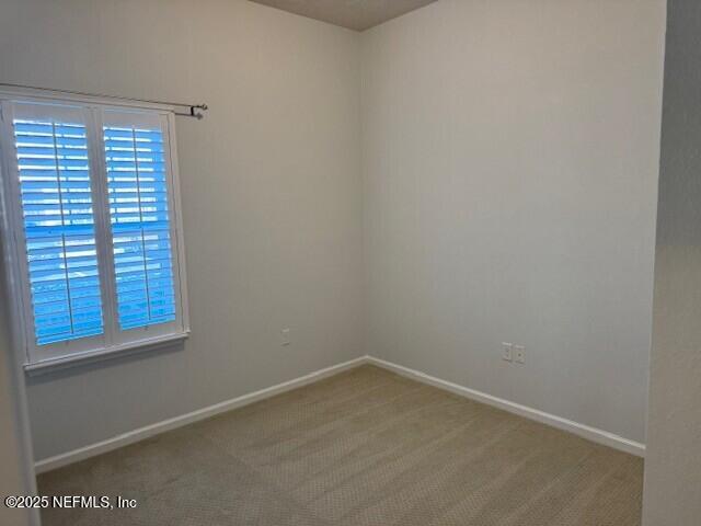 empty room with carpet flooring and baseboards