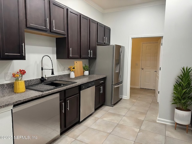 kitchen featuring dark countertops, appliances with stainless steel finishes, crown molding, dark brown cabinets, and a sink