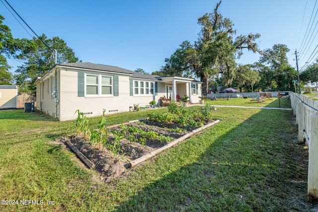 view of front of property featuring a patio area, a front yard, and central AC