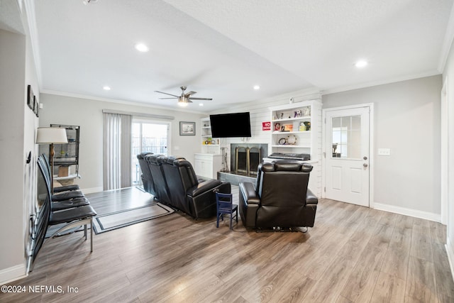 living room with light hardwood / wood-style floors, crown molding, and ceiling fan