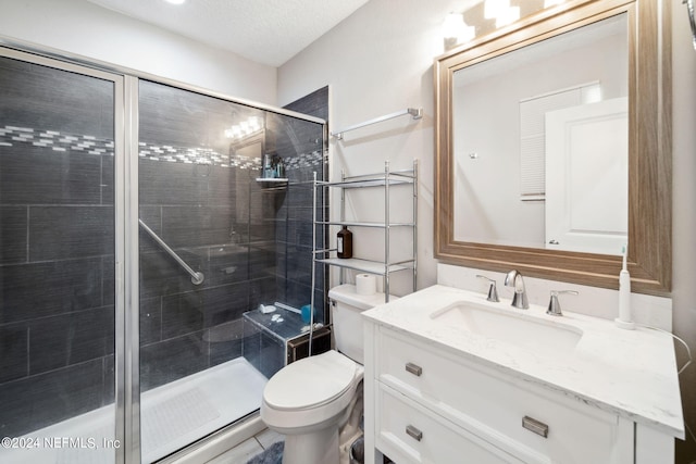 bathroom with vanity, a textured ceiling, toilet, and walk in shower