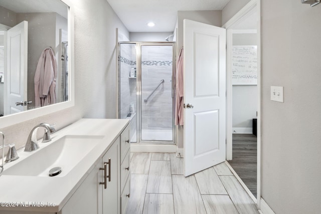 bathroom featuring a shower with door, vanity, and hardwood / wood-style floors