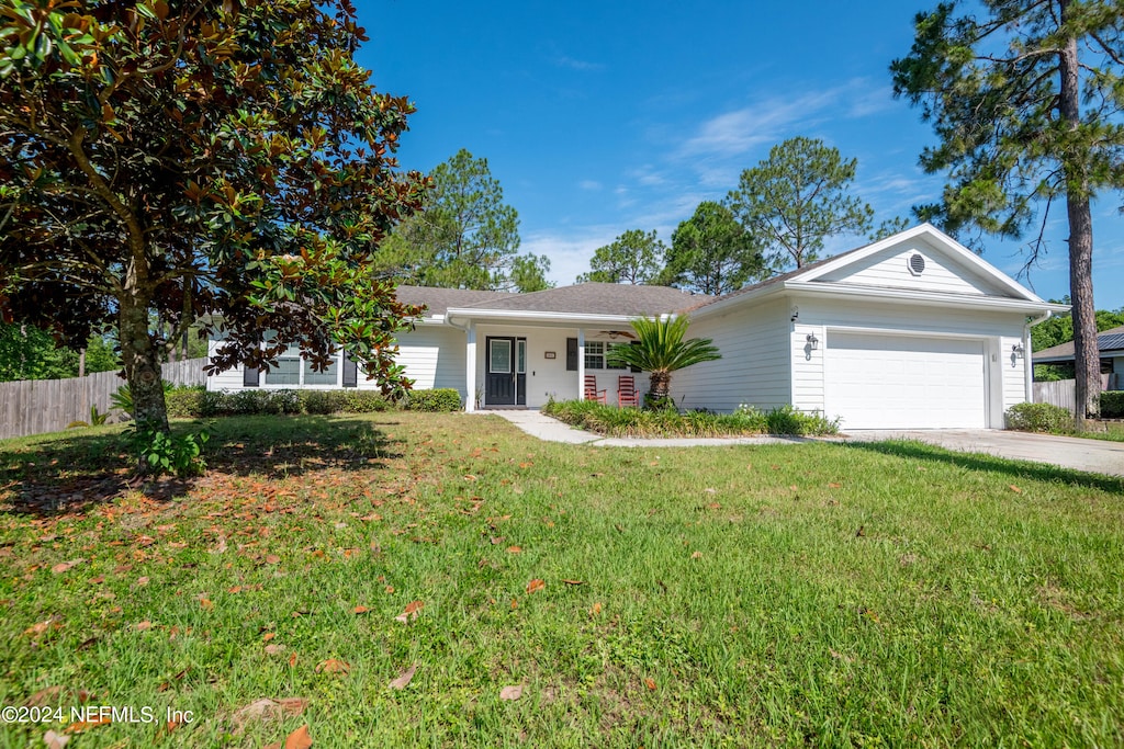 ranch-style home with a garage and a front lawn