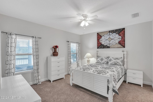 bedroom featuring a textured ceiling, ceiling fan, and carpet floors