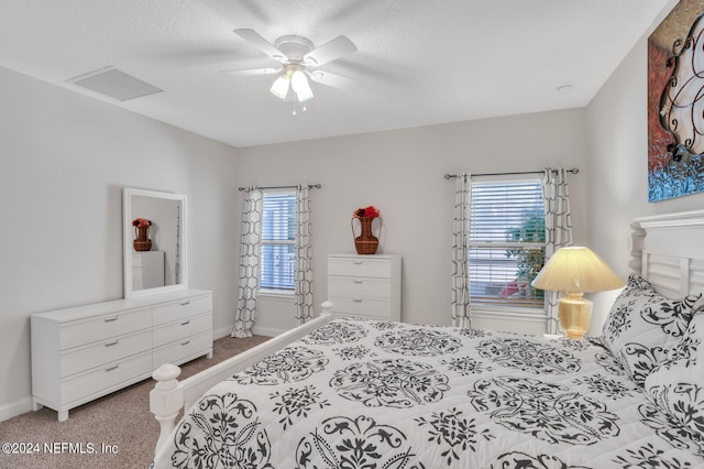 carpeted bedroom with multiple windows and ceiling fan