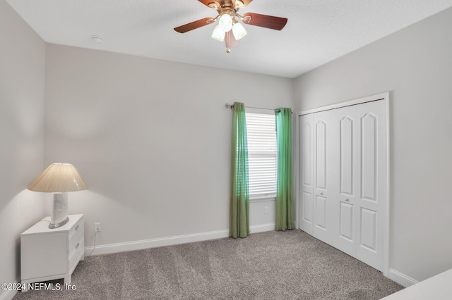 carpeted bedroom featuring ceiling fan and a closet