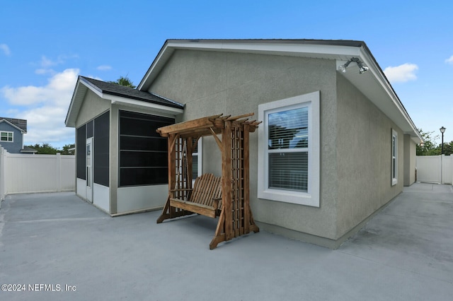 back of property with a patio and a sunroom