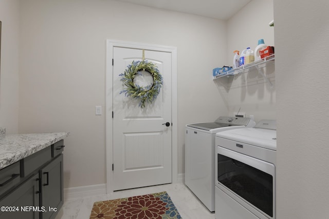 laundry room with cabinets, light tile flooring, and washing machine and clothes dryer