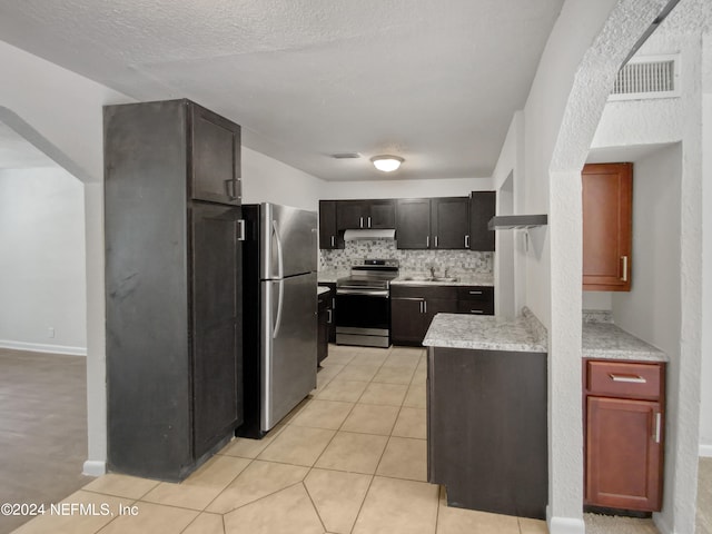 kitchen with sink, backsplash, light tile floors, and stainless steel appliances