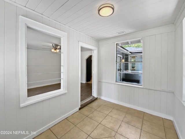 tiled spare room with ceiling fan