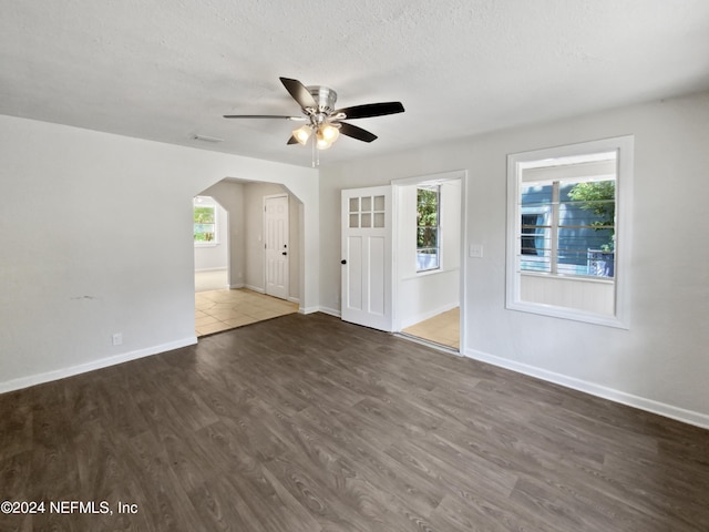 spare room featuring ceiling fan, plenty of natural light, hardwood / wood-style flooring, and a textured ceiling