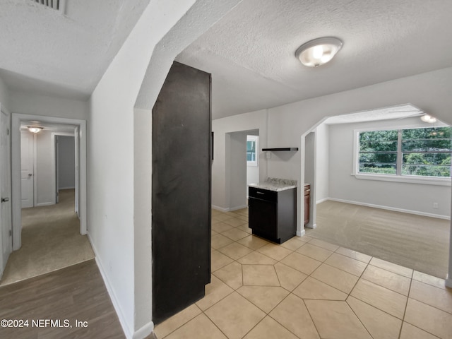 kitchen featuring a textured ceiling and light carpet