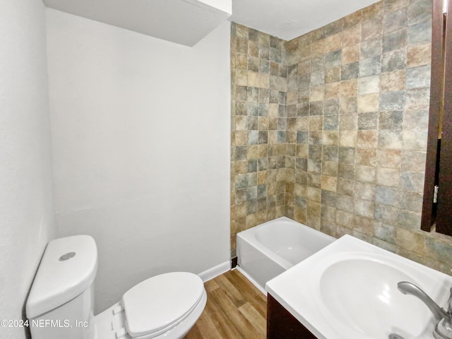 full bathroom with hardwood / wood-style floors, vanity, toilet, and tiled shower / bath combo