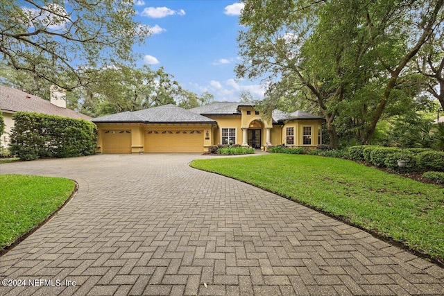 view of front of property featuring a garage and a front lawn