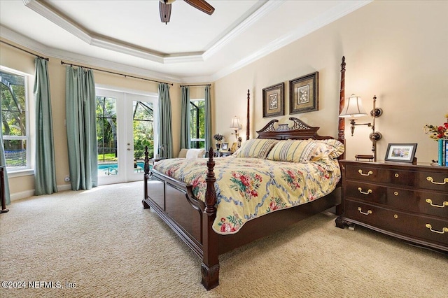 carpeted bedroom featuring access to outside, a tray ceiling, multiple windows, and ceiling fan