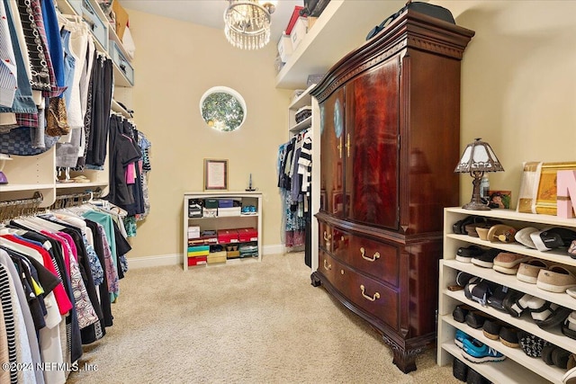 spacious closet with light colored carpet and an inviting chandelier