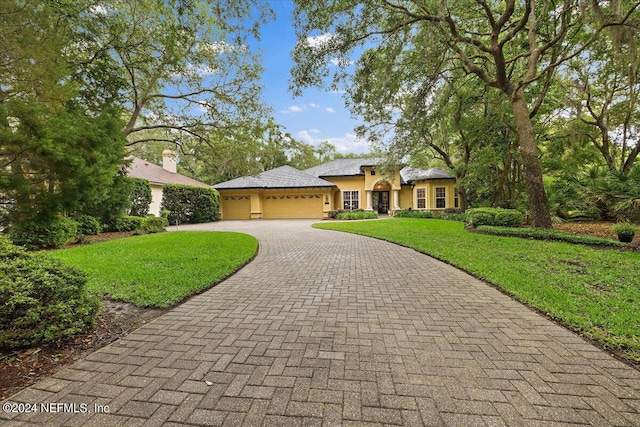 single story home featuring a garage and a front lawn