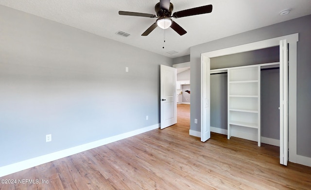 unfurnished bedroom with ceiling fan, a closet, and light hardwood / wood-style floors