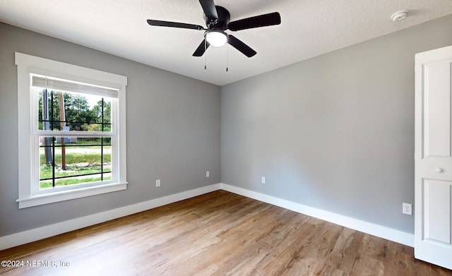 spare room with ceiling fan and light wood-type flooring