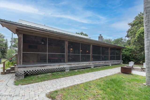 back of property featuring a sunroom and a yard