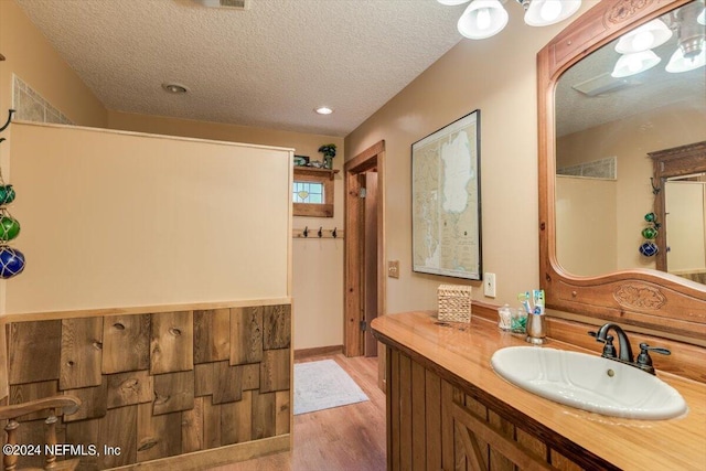 bathroom featuring hardwood / wood-style floors, vanity, and a textured ceiling