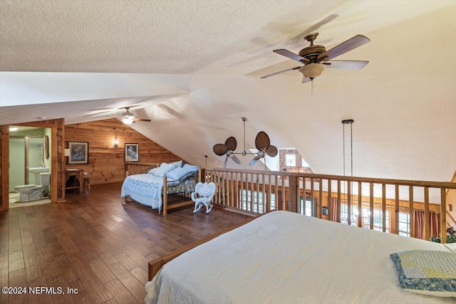 bedroom featuring ceiling fan with notable chandelier, wood walls, dark wood-type flooring, a textured ceiling, and lofted ceiling